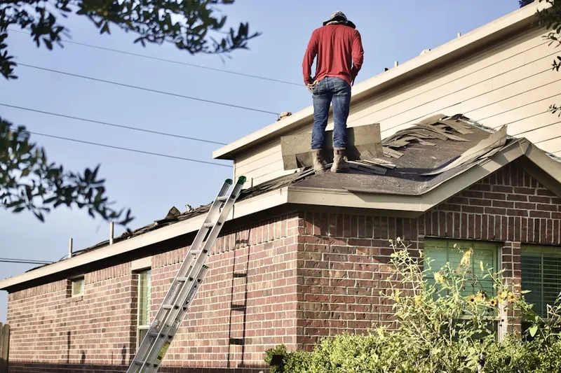 Professional roofer working on a residential roof in Harvard Heights